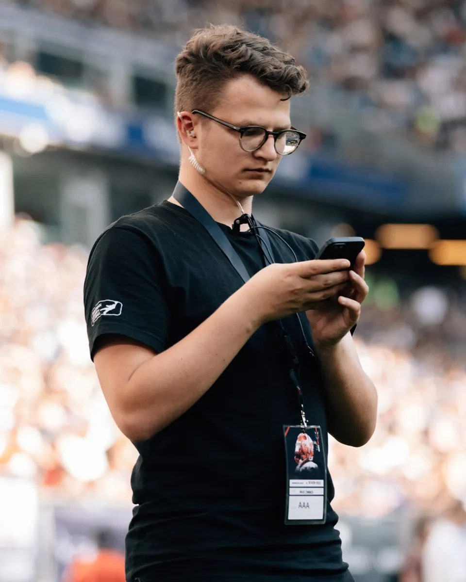 Maxi Zimmer on the field with radio earpiece and all-access credential